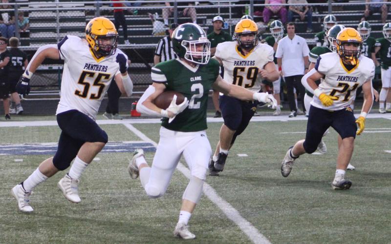 Clare’s Conan Weeks runs away from the Panthers pursuit during Friday night’s victory over visiting Standish-Sterling.