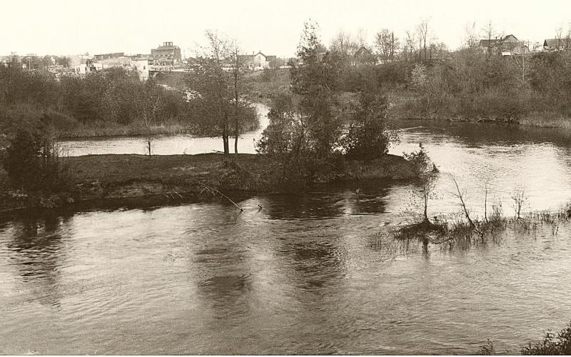 Beaverton, Michigan as viewed from the east end of the power dam’s tail race where it joins back into the Tobacco river east of town. We know this was taken after the power dam was built in 1921 and after the first stand-alone gas station was built in 1923, but before a fire destroyed the Ross Mill &amp;amp; Elevator in February 1935. JACOB AND MARIE GRANT