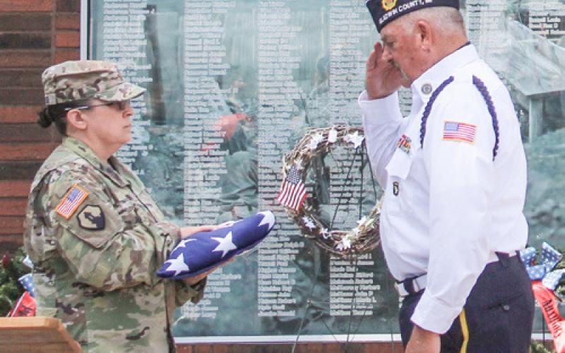 Flags were flying Monday at Gladwin’s Memorial Day service and one was folded and presented to American Legion Post 171 Commander James Volant (inset), who was named “Veteran of the Year.”
