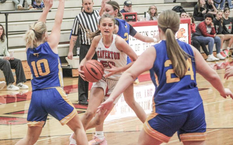 Beaverton’s Myah Hubble drives past one defender and gets ready to try and split two more during Friday night’s 54-24 victory over visiting Harrison.