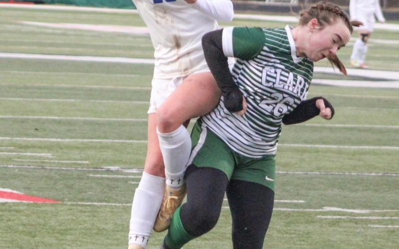 Gladwin’s Madisyn Lockwood takes flight to try to get control of the ball during Thursday’s 3-0 victory at Clare.