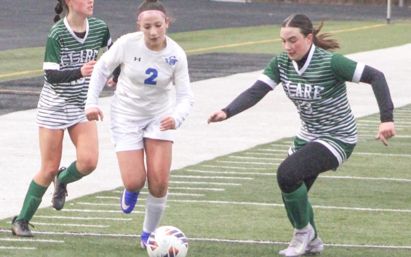 Gladwin’s Isabella Hand splits two Clare defenders and heads toward the goal during Thursday night’s victory for the Flying G’s.
