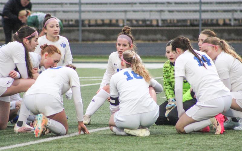 Gladwin’s soccer players gather for a quick team meeting during a break in the action Thursday at Clare.