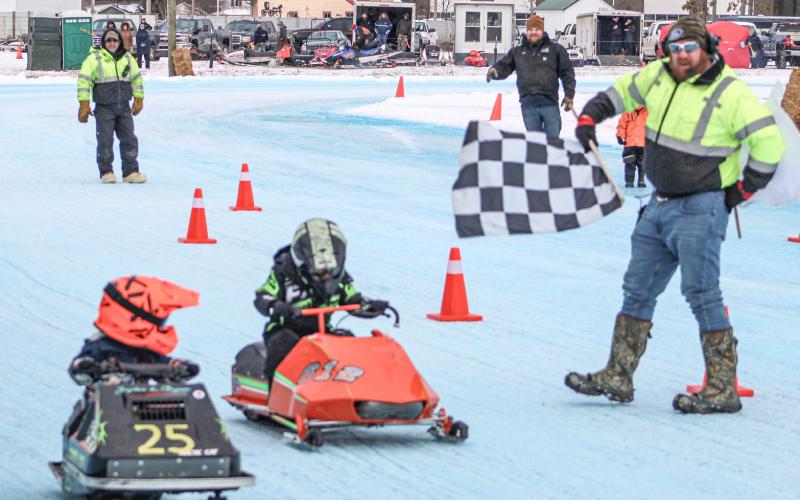 Two drivers in the Kitty Cat Division take the checkered flag at the year’s first Vintage Snowmobile Race at the Gladwin County Fairgrounds.