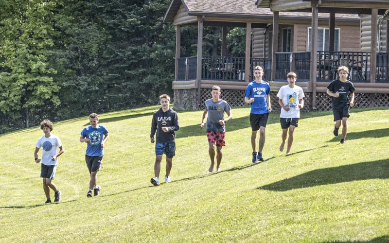 Several of the Gladwin High School Boys Cross Country team take a warm up run on the bank of the Middle Branch Tittabawassee River at Lost Arrow Resort, Gladwin, Michigan. The Boys and Girls Teams held their annual team camp beginning on August 9th and ending August 12. There are 30 athletes running cross country this year, with 23 runners returning from last year.