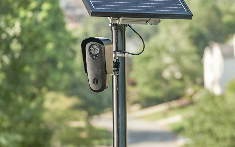 A solar-powered license plate reader mounted on a pole. FLOCK SAFET