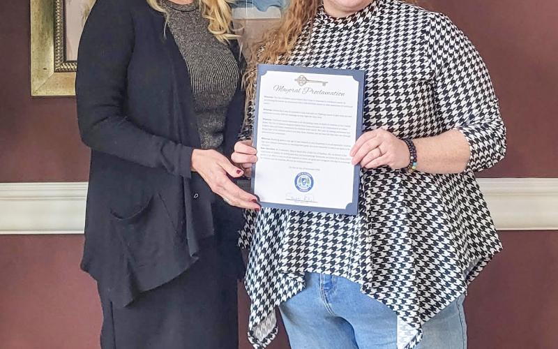 Gladwin Mayor, Sarah Kile (right), presenting a proclamation to Golden Key Camp founder, Lisa Kujawa (left), at Riverwalk Place. STEVEN HAUPT
