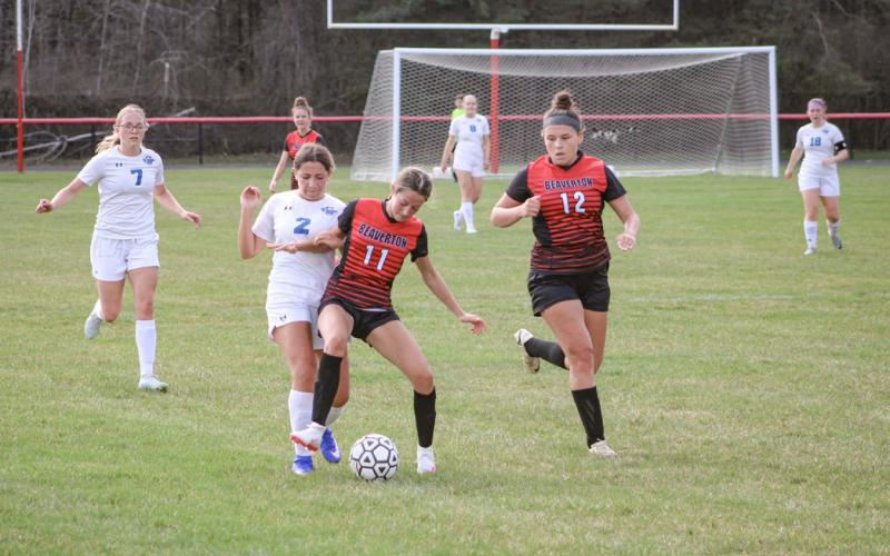Beaverton’s Wren Carland wards off Gladwin’s Bella Hand with Isabelle Dodman closing in during the first meeting between the rivals last month. The rematch is this afternoon at Gladwin.