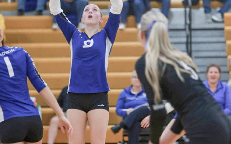 Gladwin’s Chloe Mausolf sets the table (left) and Ansley Mausolf pounds down a kill (right) during the district tournament at Ogemaw Heights.