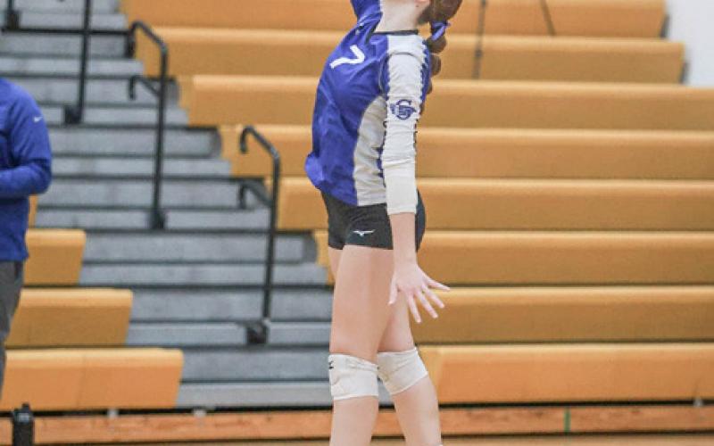 Ansley Mausolf (left) and Breanna Campbell (right) launch serves during last Tuesday’s tough season-ending loss in the district tournament at Ogemaw Heights.