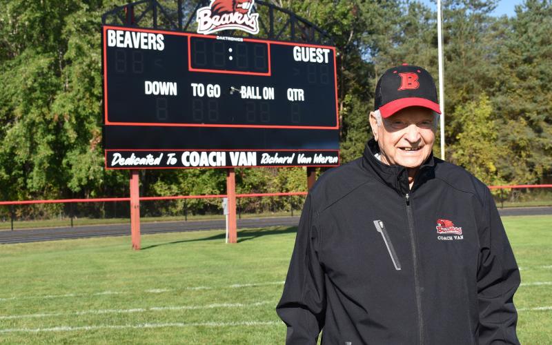 Beaverton Hall of Fame football coach Dick Van Wieren, who passed away last week, poses in front of the scoreboard that bears his name.