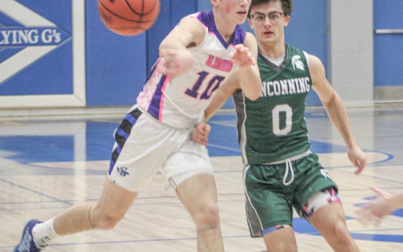 Gladwin’s Seth Mead drives and dishes during last Wednesday’s victory over visiting Pinconning in the school’s annual Coaches Vs. Cancer game.