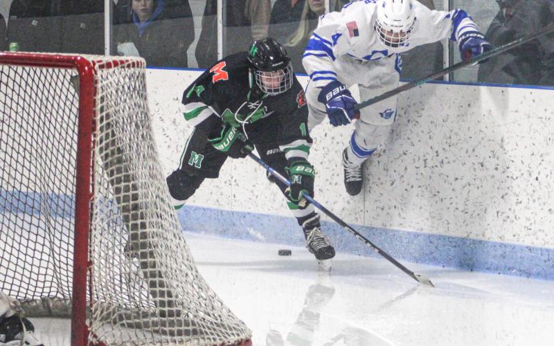 Gladwin’s Ike Wheeler gets up to try and power through a check behind the net Friday night when the Flying G’s and Manistique battled to a 2-2 tie.