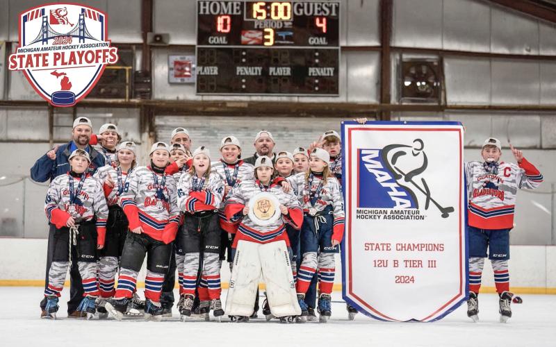 The Gladwin Gladiators hold their MAHA state championship banner on March 3. Pictured are front row, from left: Bronson Dennings, Adalynn Lechner, Payton Card, Maddyson Stalker, Avery Osentoski; second row, from left: Addison Anderson, Noah Scott, Danielle Cornell, Mia Freeman, Donovan Loose; back row, from left: head coach Ryan Harris, Mason Dern, coach Jason Newman, coach Jason Osentoski; holding banner, from left, Korbin Harris, and Preston Newman.