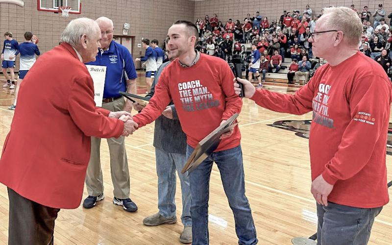 State Rep. Bill G. Schuette presents a tribute to Beaverton High School boys varsity basketball coach Roy Johnston on Friday, Feb. 23. Johnston is retiring at the conclusion of the season after coaching at Beaverton for a historic 50 seasons.