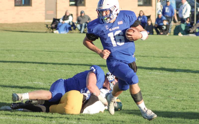 Gladwin quarterback Colton Pfenninger runs away from trouble in the backfield and heads for open spaces during the Flying G’s loss to visiting Flat Rock Thursday night.