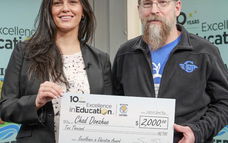Lottery Commissioner, Suzanna Shkreli (left) presented the Excellence in Education check to Chad Donahue (right). MICHIGAN LOTTERY