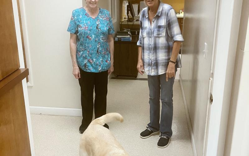 Becky Priemer and Terri Taylor send Lance off on a delivery during another work day at the Gladwin Veterinary Clinic. All three longtime employees of the business will be retiring on Aug. 28.