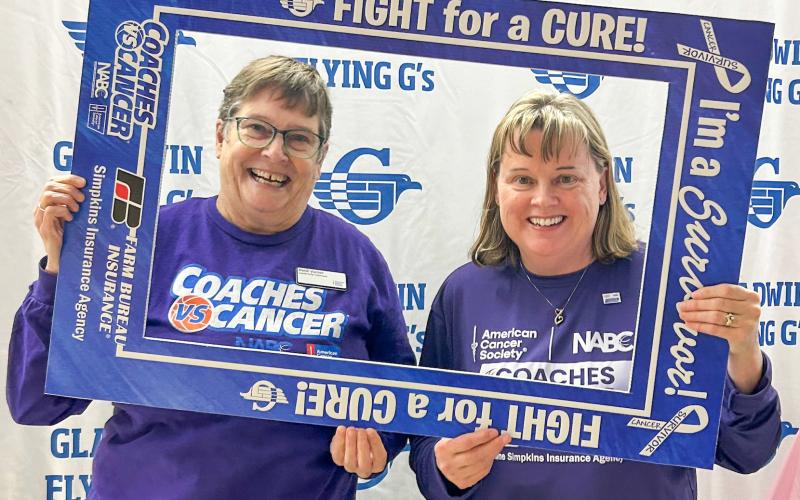 Heidi Varner of the American Cancer Society and Kim Beebe of Simpkins Insurance participate at Gladwin’s Coaches Vs. Cancer basketball game last week.