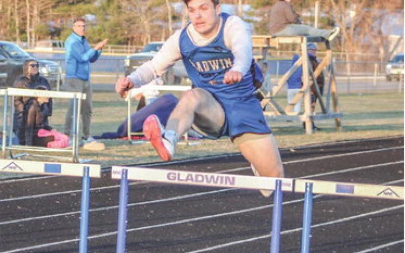 Gladwin’s Colton Pfenninger hurdles his way to a victory during the first outdoor meet of the season last Wednesday.
