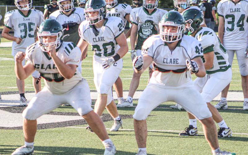 Clare’s offensive linemen get ready for battle before last week’s four-way scrimmage. The Pioneers kick off the season tomorrow night at Grayling.