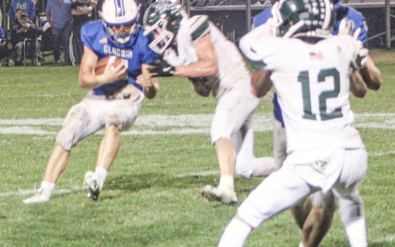 Gladwin quarterback Colton Pfenninger tries to bounce off a hit during Friday night’s dramatic loss to visiting Clare.