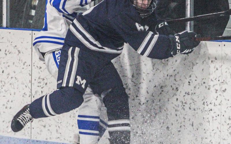Gladwin’s Drew von Matt checks a Marysville defenseman behind the Vikings net during a rugged first period for the home team on Saturday.