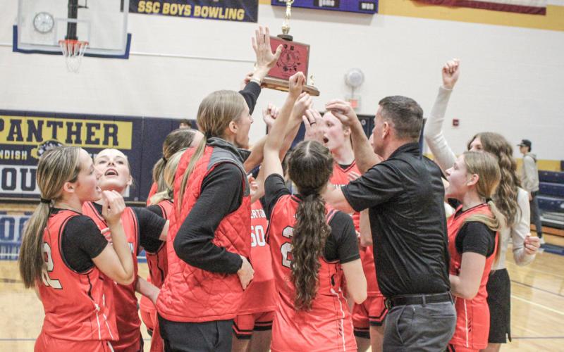 Beaverton’s players and coaches celebrate winning the Jack Pine Conference championship on the court at Standish.