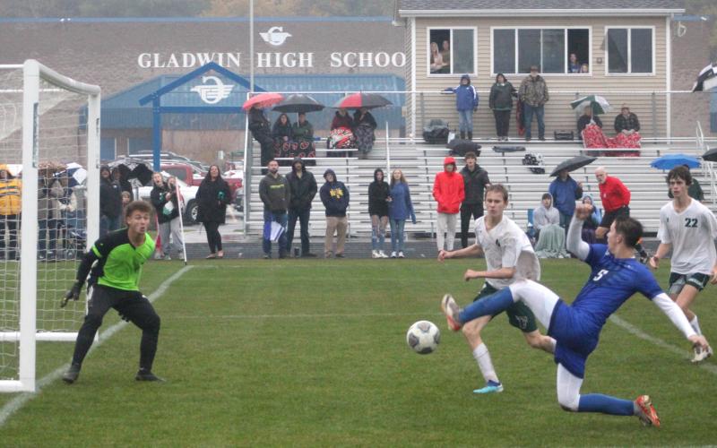 Gladwin’s Connor Ritchie stretches to the limit to try and make a play in front of Freeland’s goal during the district championship game.