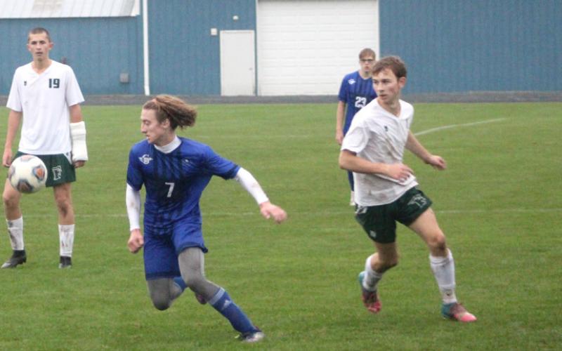 Gladwin’s Treyton Siegert zeroes in on the bouncing ball during the district championship game against Freeland.