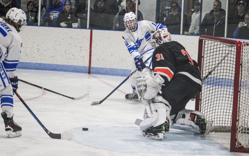 Gladwin’s Moe Newman sends a pass in front of the net to Treyton Siegert during Friday night’s victory over Cheboygan.