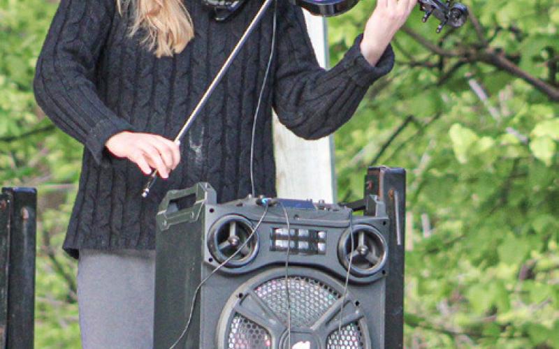 Mariah Hewitt performs the national anthem on her violin during a Memorial Day observance prior to the race Saturday.