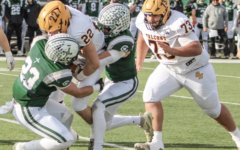 Ogemaw Heights’ Connor Lambert is taken down by two Grand Rapids West Catholic tacklers during Saturday’s state semifinal at Clare.