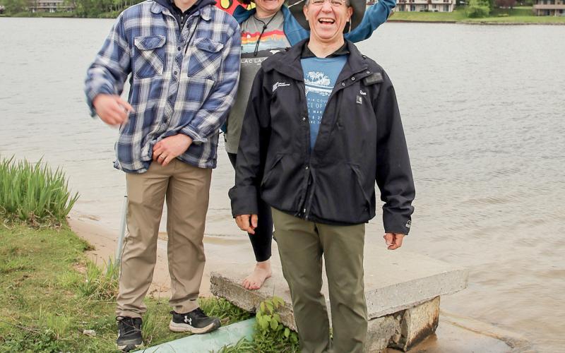Tristan Hewitt and Marah Ranke of the Gladwin County Conservation District celebrate with winner Jim Looker at the end of the River Race of Two Cities at Ross Lake Park.
