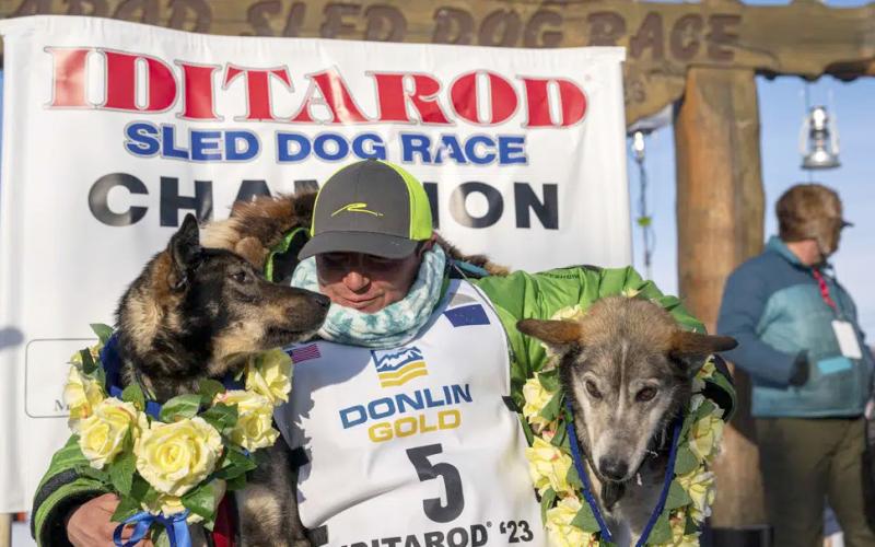 Ryan Redington poses with his lead dogs Sven, left, and Ghost, after he won the 2023 Iditarod Trail Sled Dog Race, Tuesday, March 14, 2023 in Nome, Alaska. Redington, 40, is the grandson of Joe Redington Sr., who helped co-found the arduous race across Alaska that was first held in 1973 and is known as the “Father of the Iditarod.” (Loren Holmes/Anchorage Daily News via AP)
