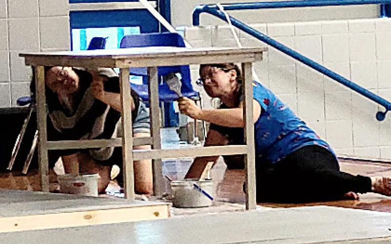 Cast member Katrina Doud (“Yente The Matchmaker”) and Lorraine Carman “Fruma Sarah”) painting for Fiddler On The Roof.