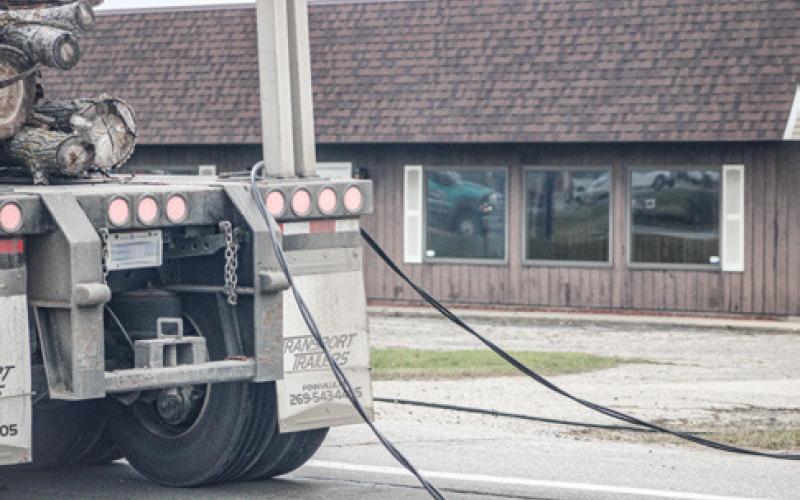 Smoke, fire and sparks were the results when a pair of utility poles snapped after a truck carrying a load of logs snagged the power lines crossing M-61 on the afternoon of Dec. 3.