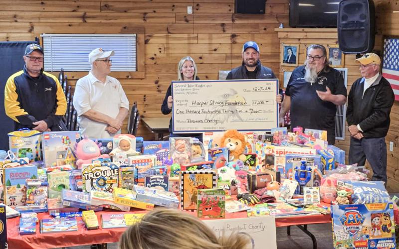 Shelly and Justin of Harper Strong accept a check and a table full of toys from Secord Lake Eagles President Ward Komer and the Aerie’s Executive Board during a ceremony at the club on Sunday.