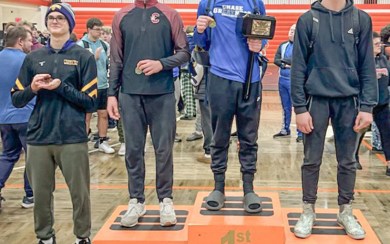 Gladwin’s M.J. McDonald poses on the podium after winning his weight class championship and being named MVP at a tournament at Manton Saturday.