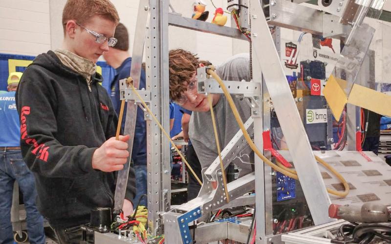 Noah Burgess and Dylan Northrup work on assembling the BeaverTech robot prior to last weekend’s robotics competition at Midland Dow.