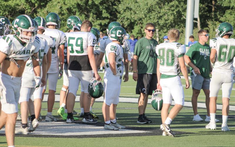 Clare coach Steven Spangler addresses the troops on the field. The Pioneers are 1-0 after a win at Grayling Thursday.