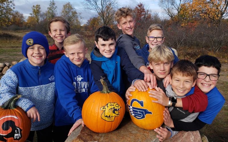 The boys posing with a pumpkin painted by the host school art classes.