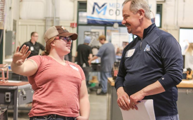 Mid Michigan College President Tim Hood converses with Mariah Huguelet.