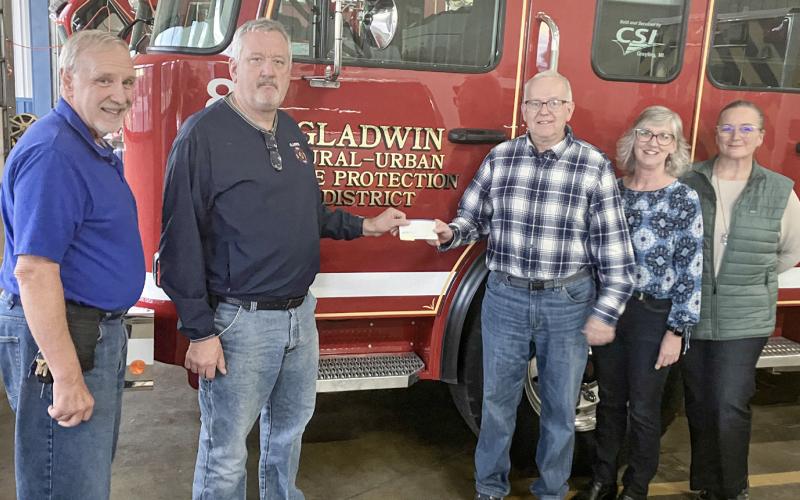 Pastor David Sprang and John Caffrey of the Gladwin Rural Urban Fire Department present a check for $1,000 to Kevin Brott, Lanette Morgan and Candace Pennell of the New Dawn Shelter. The funds for the donation were raised at the department’s golf outing in August.