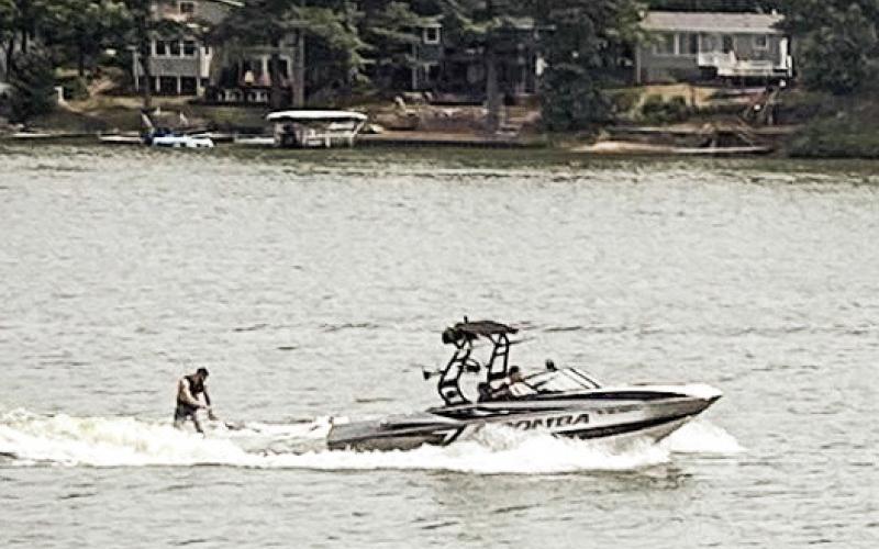 A wake boat tugging a wakeboarder cuts across Brooks Lake on a recent weekend afternoon. EMILIO PEREZ IBARGUEN/BRIDGE MICHIGAN