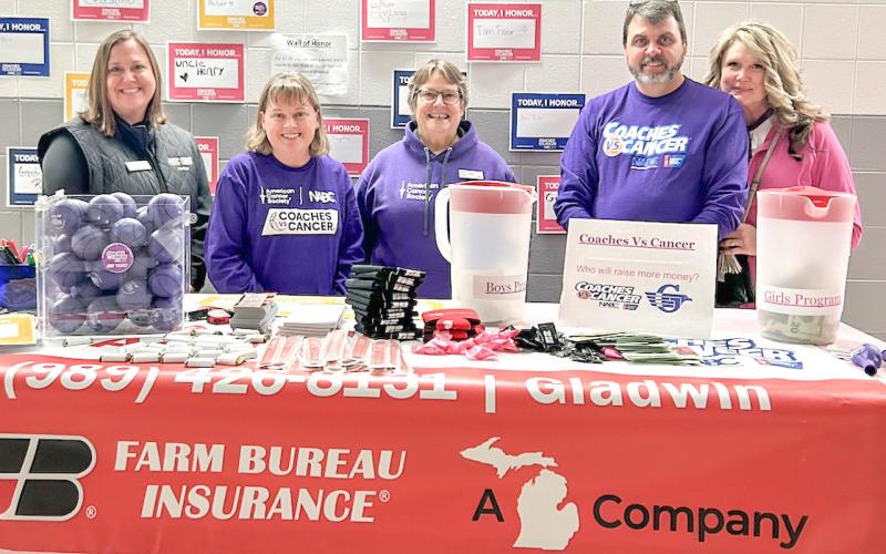 Taking care of the Farm Bureau Insurance sponsor’s table at last year’s Coaches vs. Cancer basketball game at Gladwin were (left to right) Mary Lynn Robertson, Kim Beebe, Heidi Varner, Duane Simpkins and Lisa Simpkins.