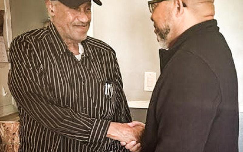 Lawrence Brooks (left) shakes hands with MVAA Director Brian L. Love.