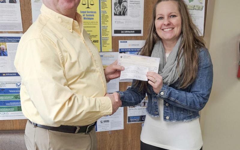 Tom Fruchey presents a check to Shavonne Brubaker of Community Mental Health for Central Michigan.