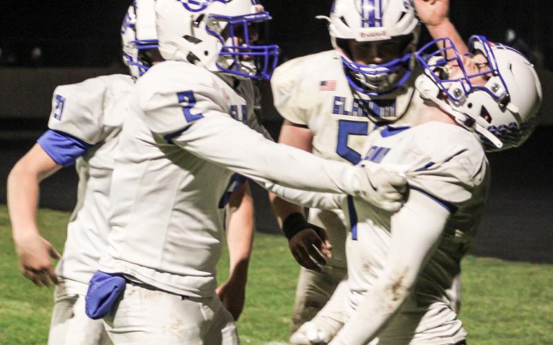 Gladwin’s Trace Corlew celebrates with his teammates after returning a punt for a touchdown Friday night in the district final at Ogemaw Heights.
