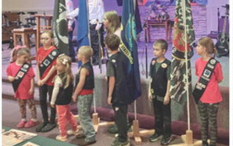 Members of the Road Rangers and the Girls’ Ministry youth groups at Gladwin Assembly of God stand with the flags of the different branches of the service at Sunday’s salute to Vietnam veterans.